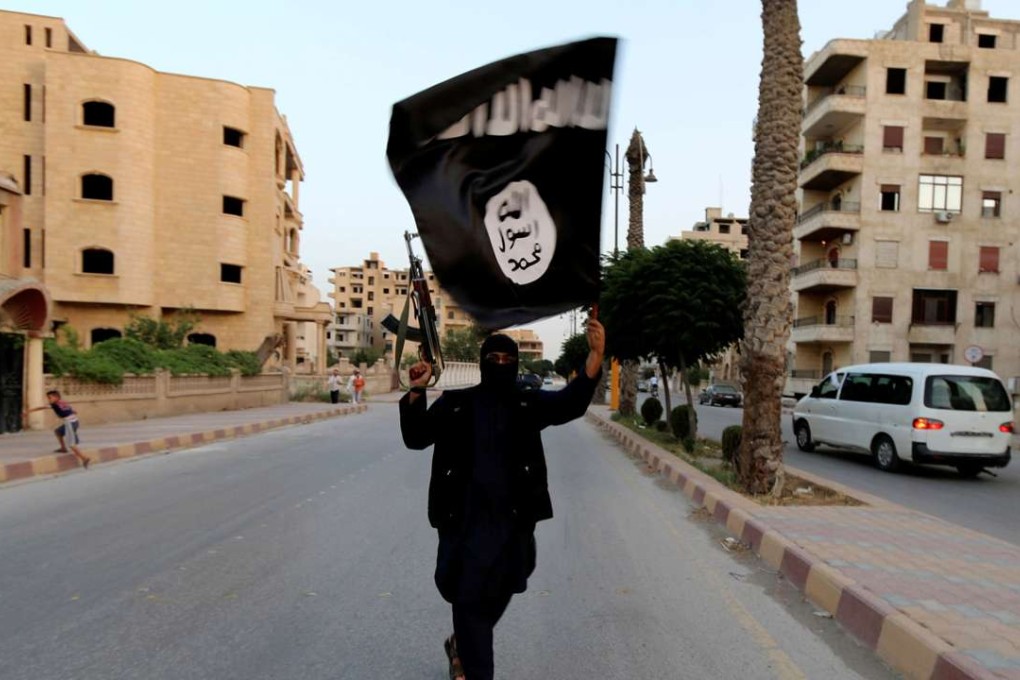 In this June 2014 file photo, a member loyal to Islamic State waves a flag in Raqqa in Syria. Photo: Reuters
