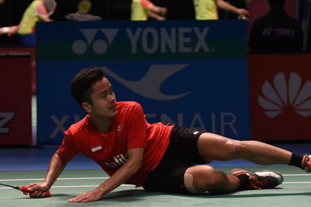 Anthony Sinisuka Ginting of Indonesia falls as he hits a return to China's Chen Long. Photos: AFP