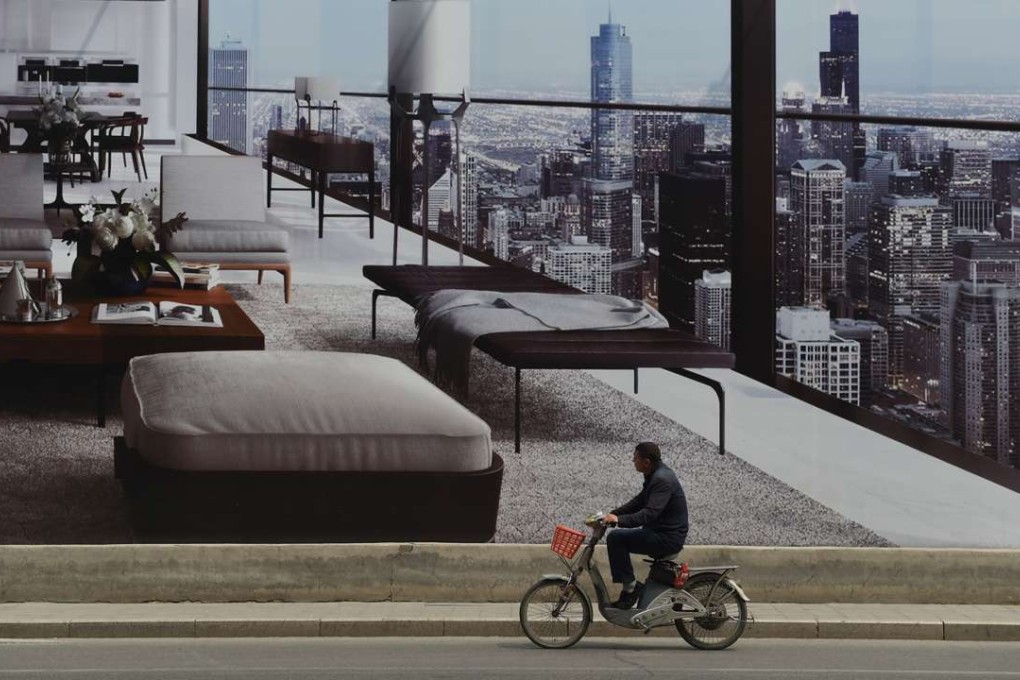 A man cycles past a billboard advertising a new housing complex in Beijing. Rising corporate debt was ‘a key fault line in the Chinese economy’, said the IMF No2 official. Photo: AFP