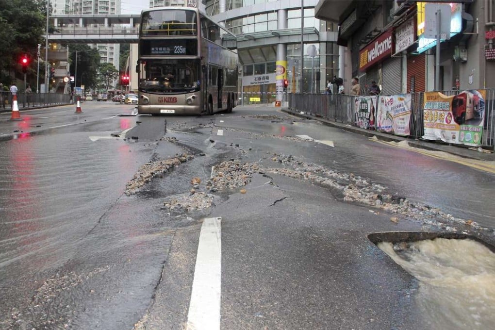 A bus is trapped in part of the road that subsided following a water pipe burst. Photo: SCMP Pictures