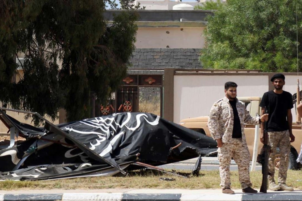Forces loyal to Libya's UN-backed unity government stand next to an Islamic State (IS) group flag in Sirte's centre as they advance to recapture the city from the jihadists. Photo: AFP