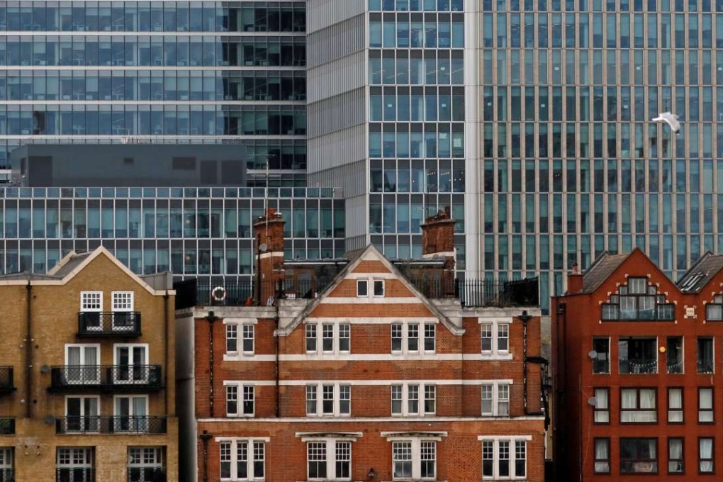 Long office leases seen protecting investors from short-term fluctuations. Photo: Reuters Apartment buildings are backdropped by skyscrapers of banks at Canary Wharf in London, Britain October 30, 2015. REUTERS/Reinhard Krause/File Photo