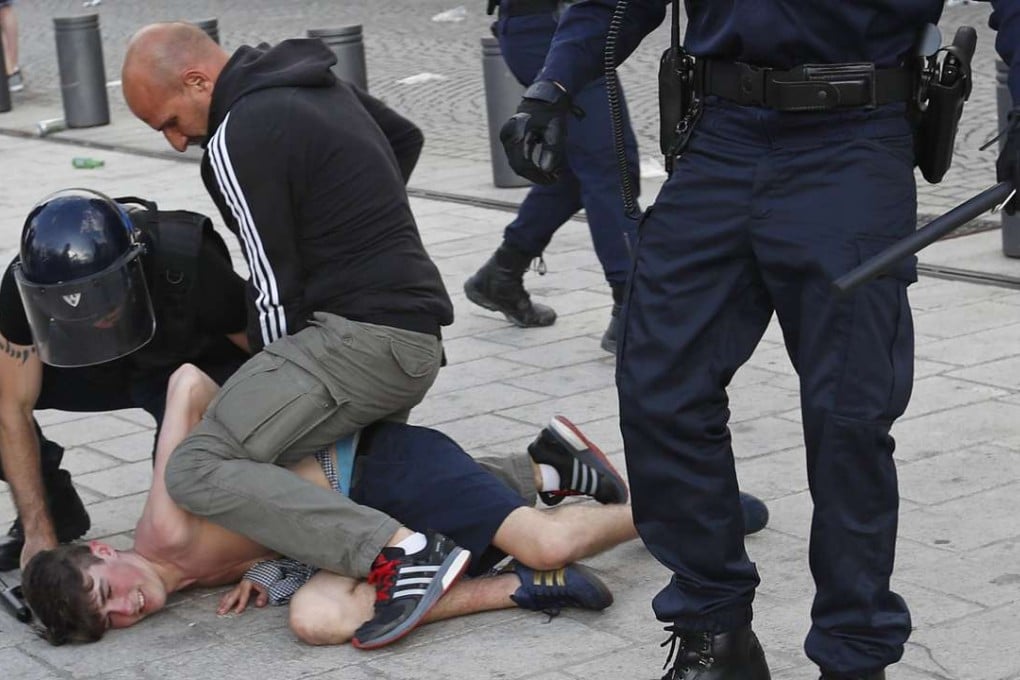 French police apprehend a man in downtown Marseille. Arrests were made and a number of troublemakers have already been jailed for their actions. Photo: AP