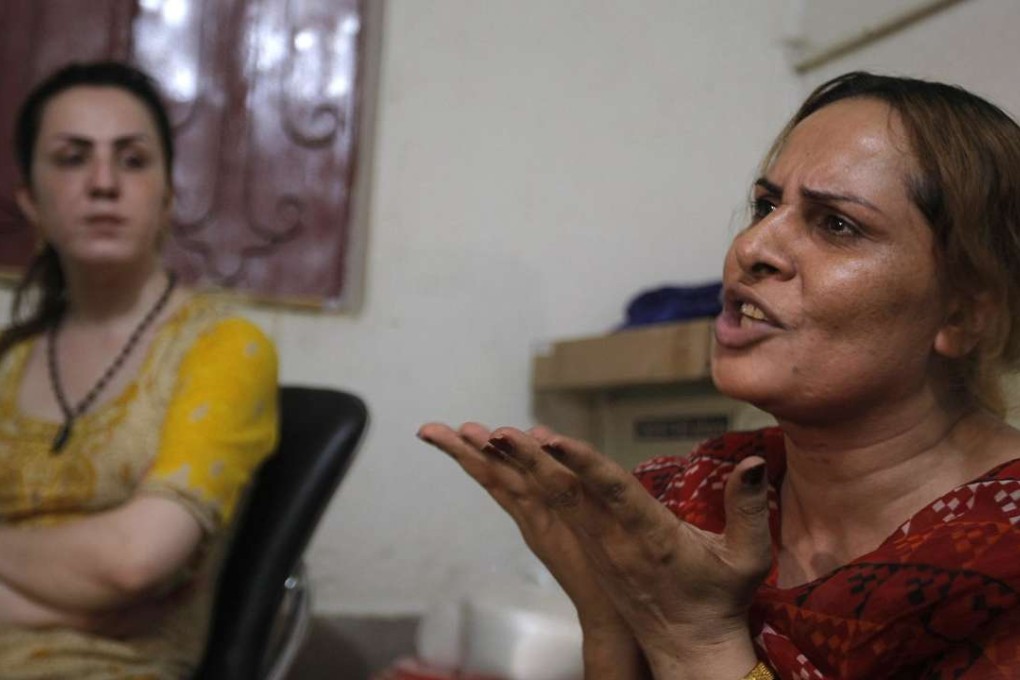 In this Tuesday, May 31, 2016 photo, Pakistani transgender guru Farzana, right, tells what happened to her colleague Alisha who was killed in Peshawar, Pakistan. Alisha was shot five times allegedly by her boyfriend who has since been arrested. She died of her wounds three days after being admitted to hospital. Her friends say she was neglected by doctors and medical professionals, who taunted her, rather than treated her. (AP Photo/Mohammad Sajjad)