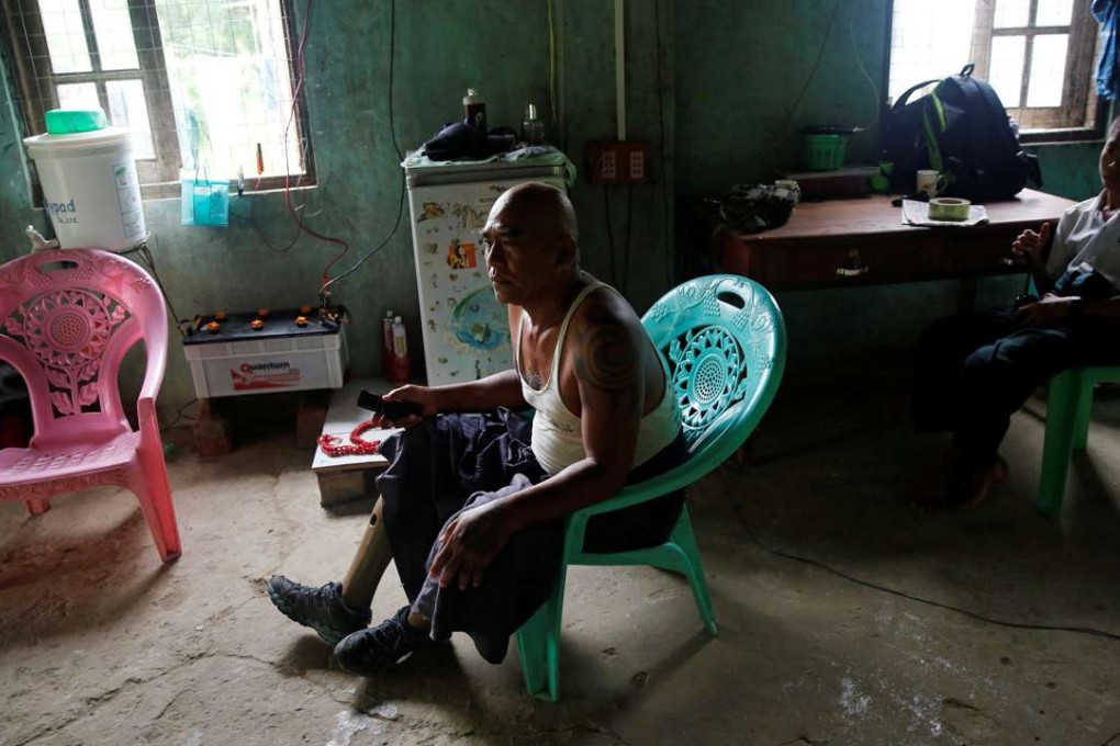 Aung Gyi, 60, a former soldier who lost both legs after he stepped on a landmine during fighting against communists, sits at his house outside Yangon, Myanmar. Photos: Reuters.