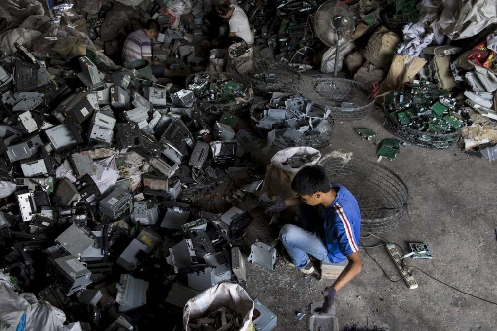 A worker recycles CD players at a workshop in Guiyu, in Guangdong. The town is known as one of the world’s largest electronic waste dump sites. Photo: Reuters