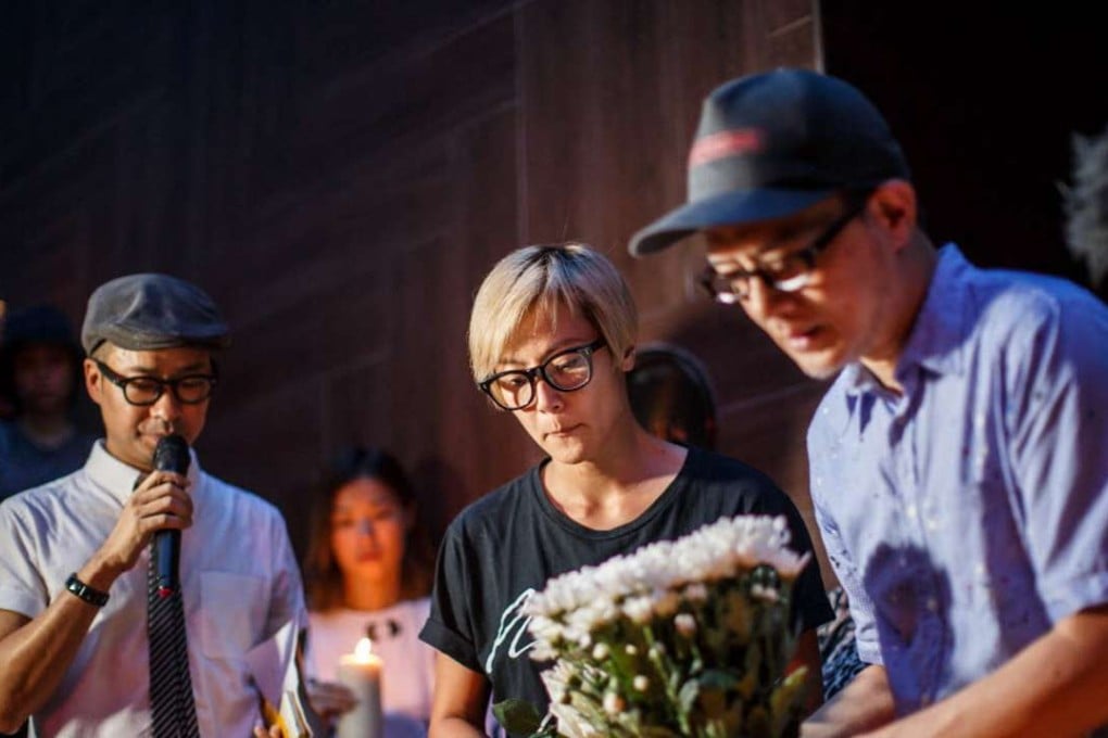 Denise Ho Wan-sze (centre) laying flowers at a vigil in Hong Kong on Monday for shooting victims in Orlando, Florida. Photo: AFP