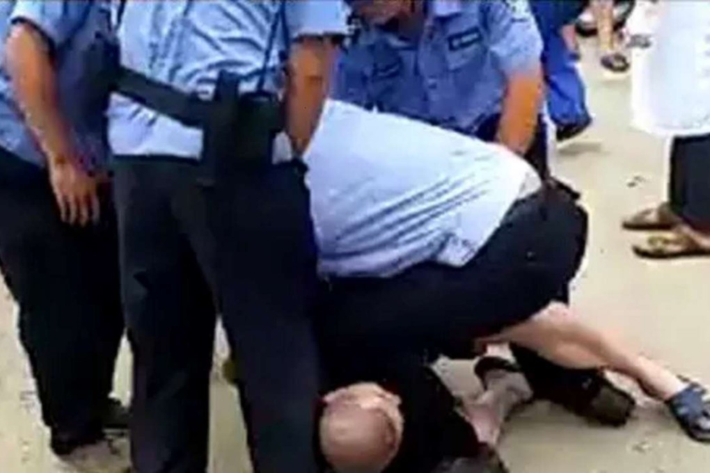Li Gang is wrestled to the ground and beaten by uniformed men in Dongguan late last month. Photo: Information Times
