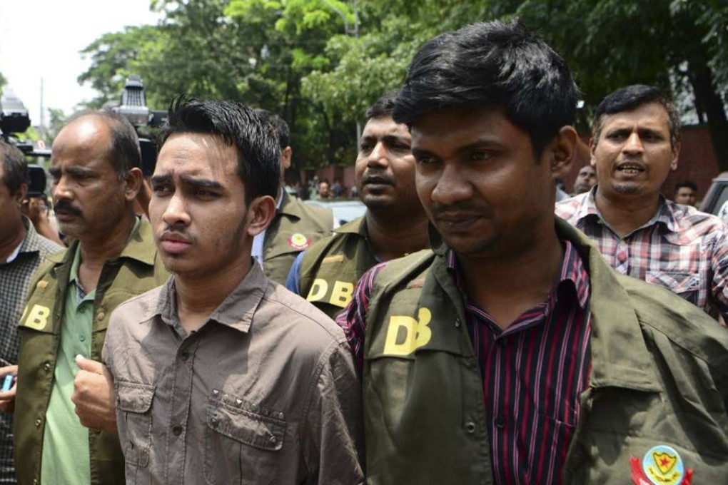 Bangladesh police escort Suman Hossain Patowari (centre) on Thursday after his arrest in connection with an attack on publisher Ahmedur Rashid Tutul last year. Photo: AFP