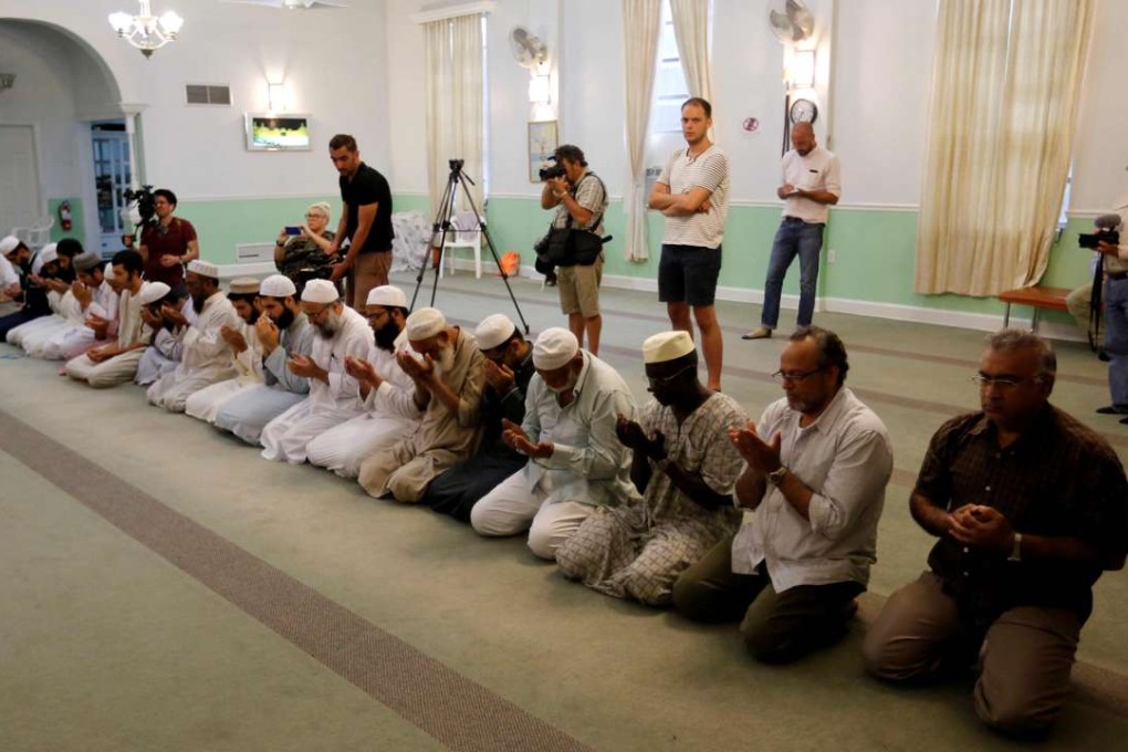 Worshippers listen as Imam Syed Shafeeq Rahman of the Islamic Centre of Fort Pierce offers a prayer for victims of the Orlando shooting, in Fort Pierce on Sunday. Photo: Reuters