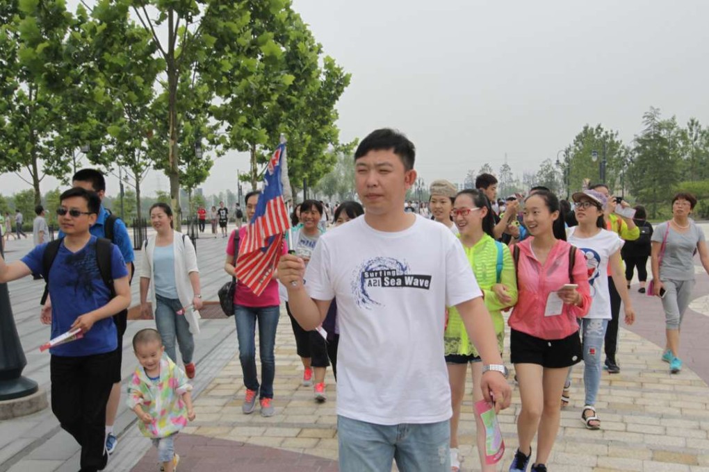 A tour group visits Disneyland on its opening day. Photo: Simon Song