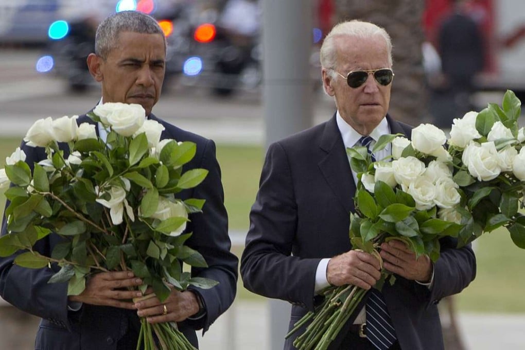 US President Barack Obama with Vice-President Joe Biden carry bouquets comprised of a total of 49 white roses, one in honor of each of the deceased victims, as they visit a memorial to the victims of the Pulse nightclub shooting on Thursday in Orlando, Florida. Photo: AP