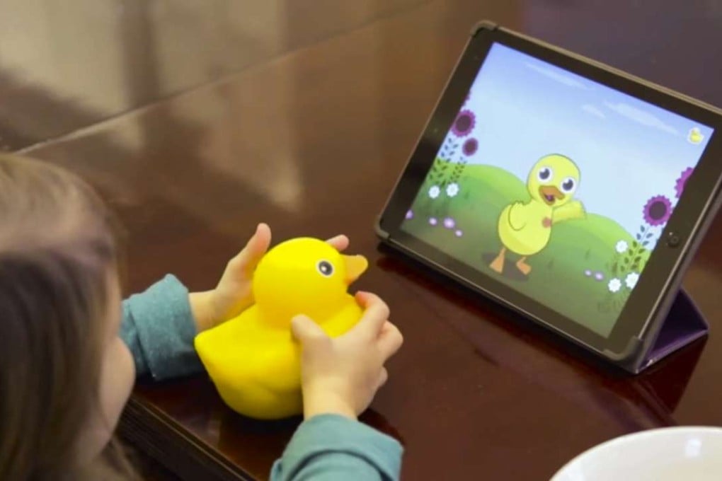 A child plays with Edwin the Duck, a digital duck toy.