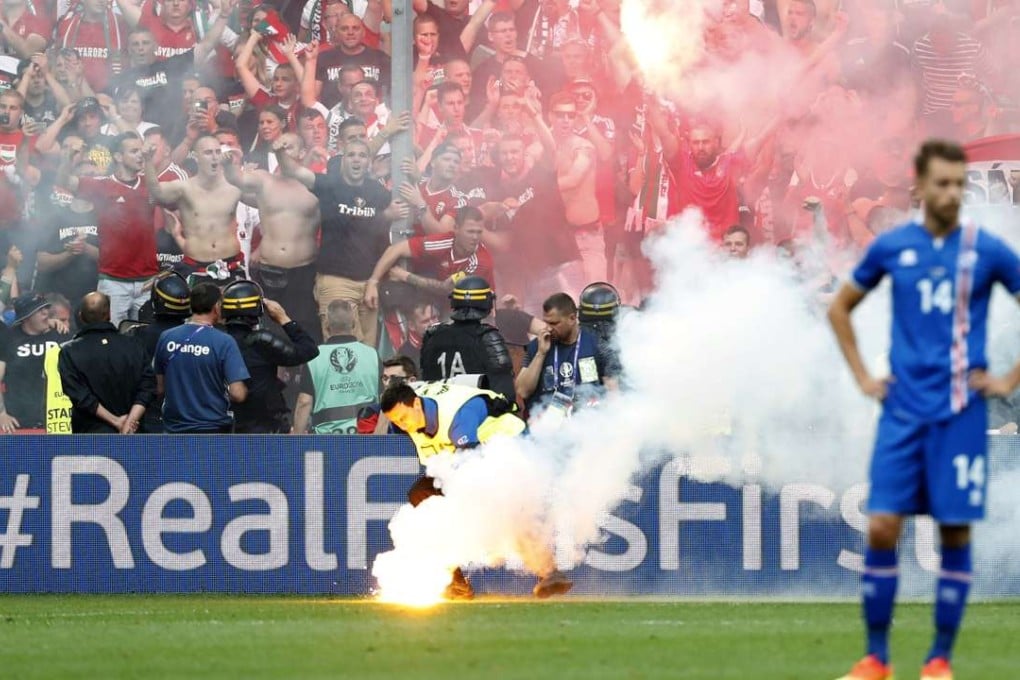 Iceland's Kari Arnason reacts as a steward picks up a flare thrown onto the pitch by Hungary fans after their first goal REUTERS/Yves Herman Livepic