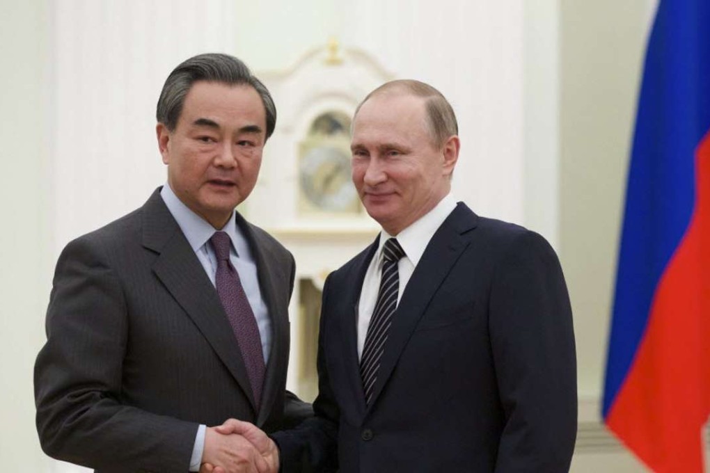 Russian President Vladimir Putin shakes hands with Chinese Foreign Minister Wang Yi during a meeting at the Kremlin in Moscow in March 2016. Photo: AFP