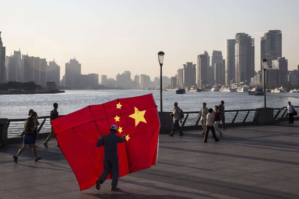 A man carrying a kite in the shape of the Chinese national flag walks along the Bund in Shanghai. The country’s debt-fuelled rapid economic growth has been a major wind at the back of the world economy for the past 20 years. Photo: Bloomberg