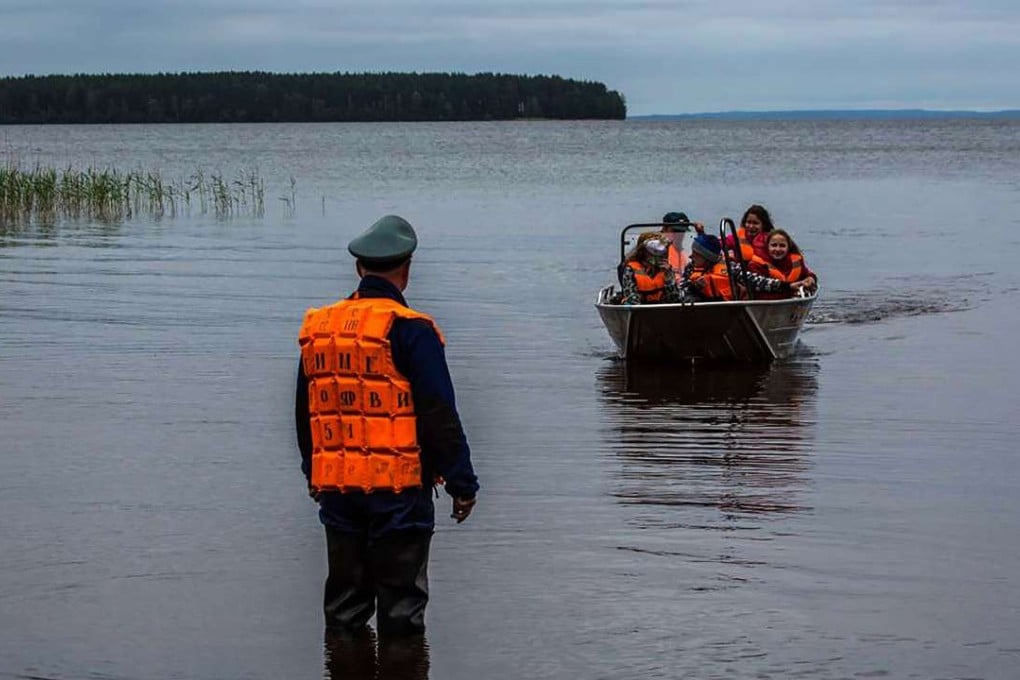 Young survivors of a boating tragedy on Lake Syamozero in Russia's autonomic republic of Korelia reach shore on Sunday. At least 14 children on a summer camp i drowned when their boats capsized in a storm on the lake, investigators said. Photo: AFP