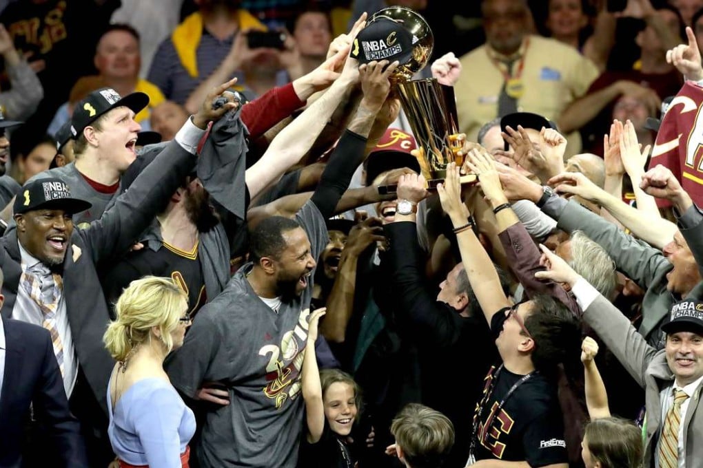Cleveland Cavaliers owner Dan Gilbert, holds the Larry O'Brien Championship Trophy after the Cavaliers defeated the Golden State Warriors 93-89. Photos: Getty Images/AFP