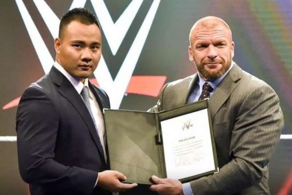 Chinese WWE wrestler Bin Wang at his ceremonial contract signing with Triple H. Photos: WWE.com