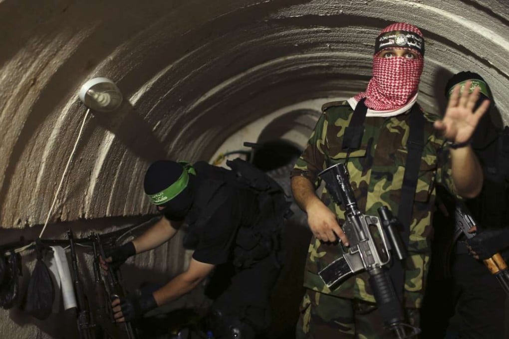 A Palestinian fighter from the Izz el-Deen al-Qassam Brigades, the armed wing of the Hamas movement, gestures inside an underground tunnel in Gaza, on August 18, 2014. Photo: Reuters