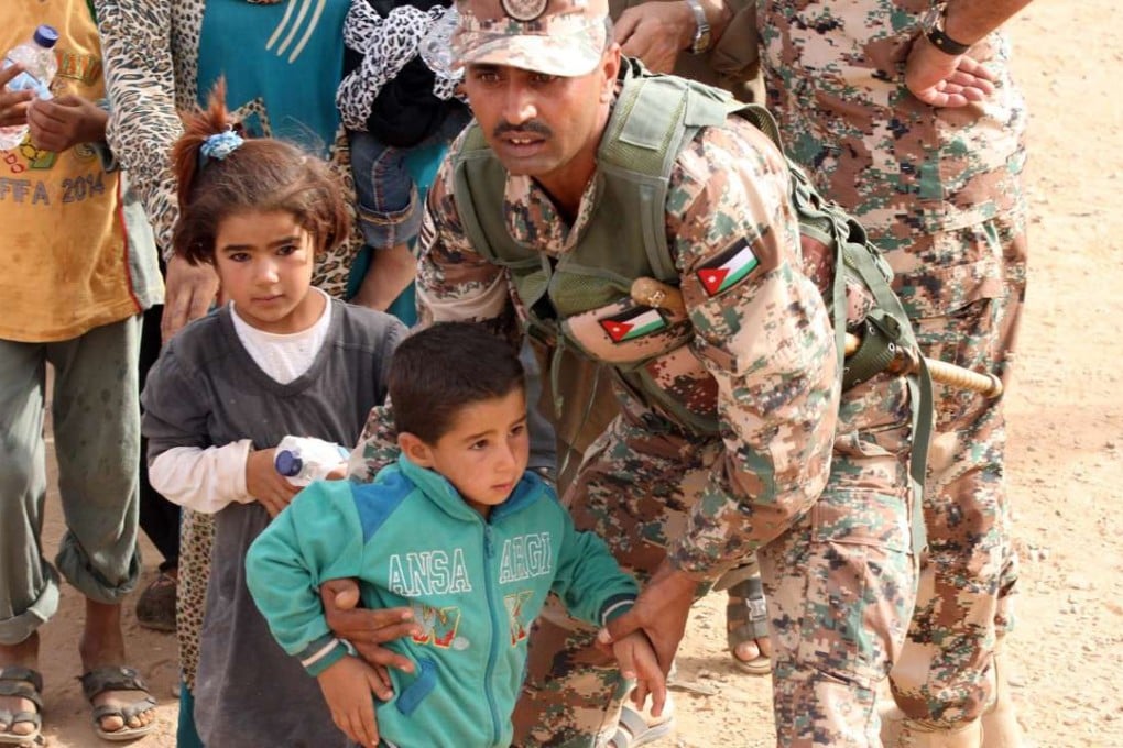 A Jordanian soldier helping Syrian refugees children upon their arrival at the Jordan-Syria border in 2015. Photo: EPA