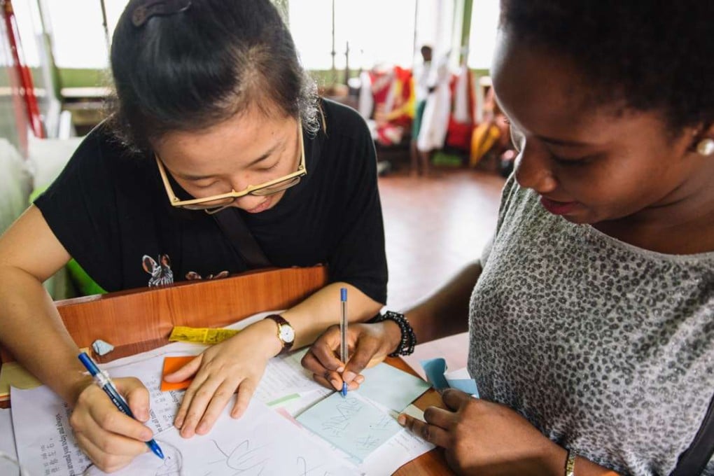A local student (right) learns to write “I love my home” in Chinese at the Confucius Institute of the University of Lagos in Nigeria. Photo: Xinhua