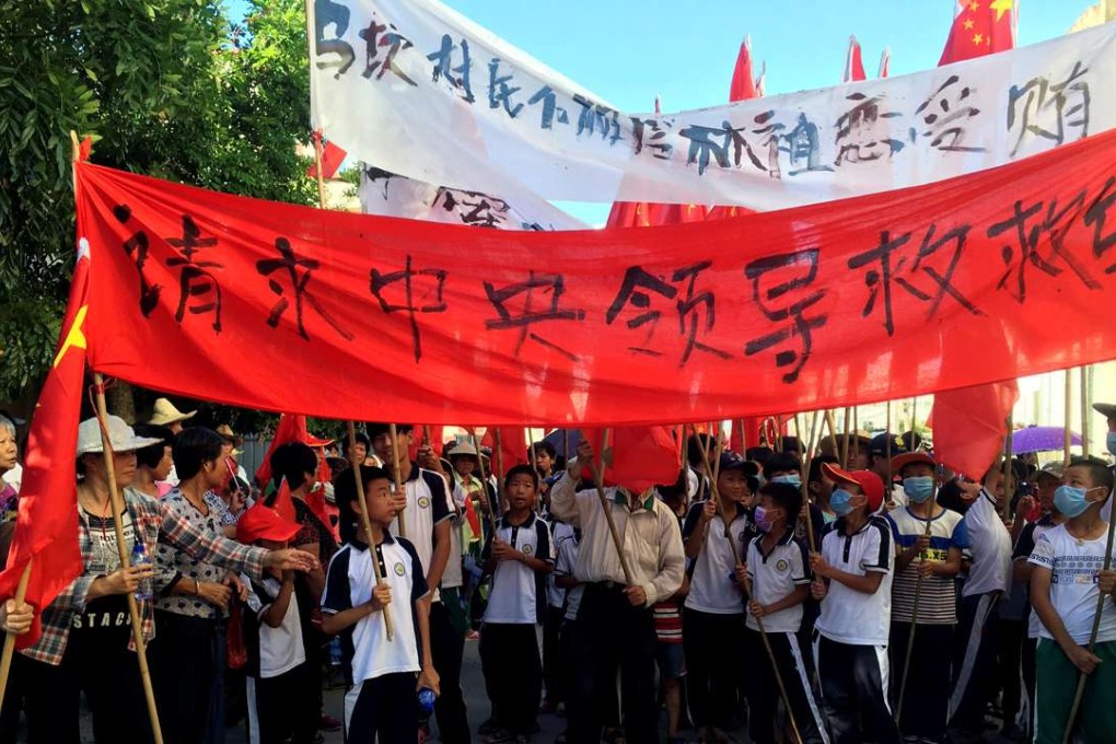 Villagers carry banners which read “Plead the central government to help Wukan” (in red) and “Wukan villagers don't believe Lin Zuluan took bribes” during a protest in Wukan, Guangdong province on Wednesday. Photo: Reuters