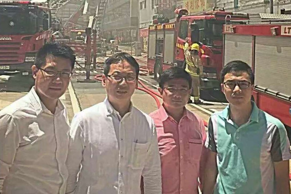 The DAB members pose for a photograph at the scene of the fire. A fireman who tackled the blaze later died. Photo: SCMP Pictures