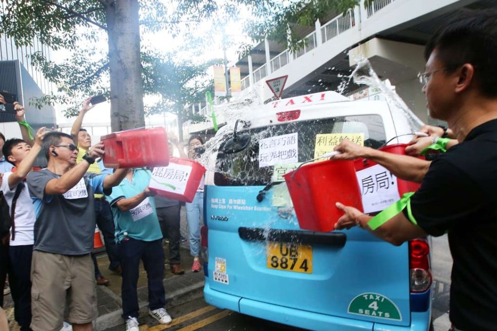 Protesters at Tamar pouring water over a model of taxi that would be used in the government’s plan. Photo: David Wong