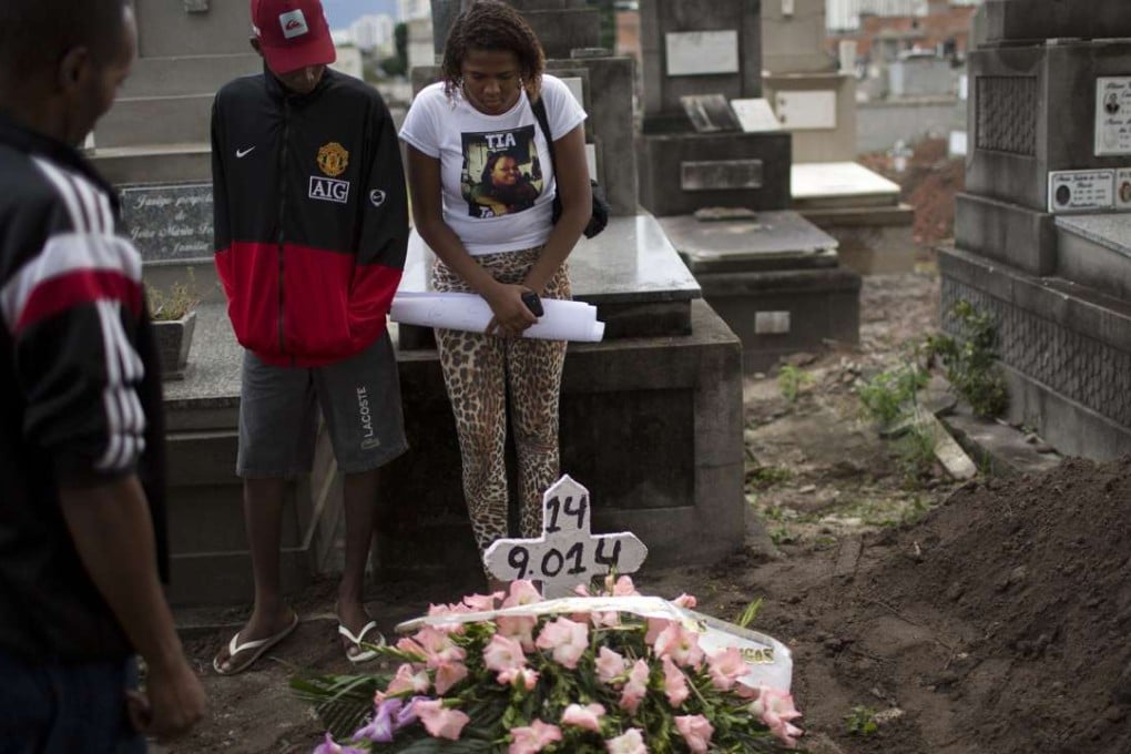 Relatives and friends attend the burial of Roseli dos Santos de Jesus, 31, killed by a stray bullet during a shooting between police and drug traffickers, in Rio de Janeiro, on Tuesday. Killings by police are under scrutiny following the recent shooting of a 10-year-old car thief. Photo: AP