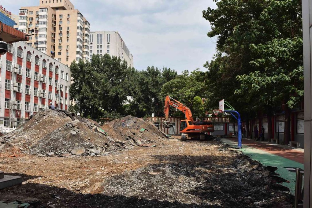 An excavator rips up the play area and track at the Baiyunlu campus of the Beijing No. 2 Experimental School. Toxic chemicals in the surface allegedly poisoned dozens of pupils. Photo: Xinhua