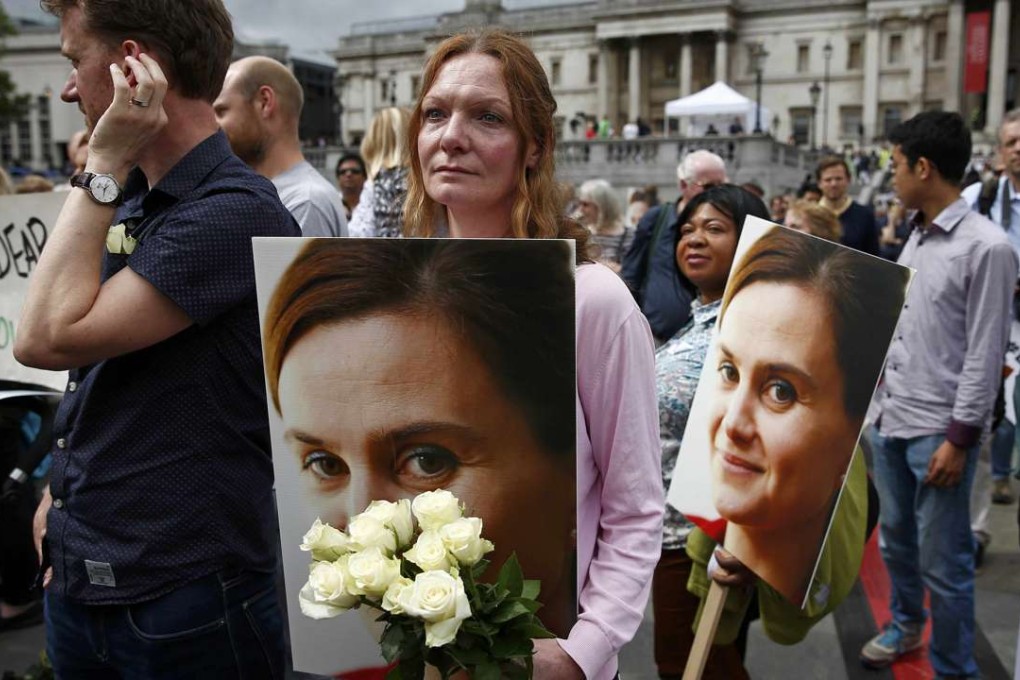 A woman holds a placard and white roses during a memorial service for murdered Labour MP Jo Cox, at Trafalgar Square in London. Cox had a reputation for a liberal stance on immigration and a humanitarian approach to refugees. Photo: Reuters