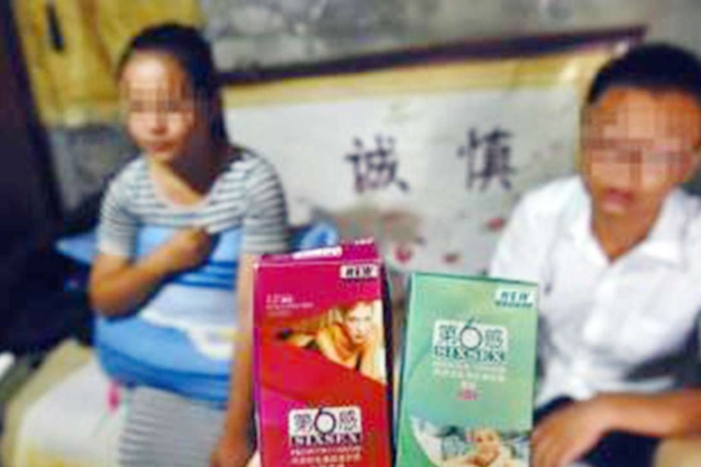 The unidentified couple display the dodgy condoms that resulted in the girlfriend getting pregnant twice in three months. Photo: SCMP Pictures