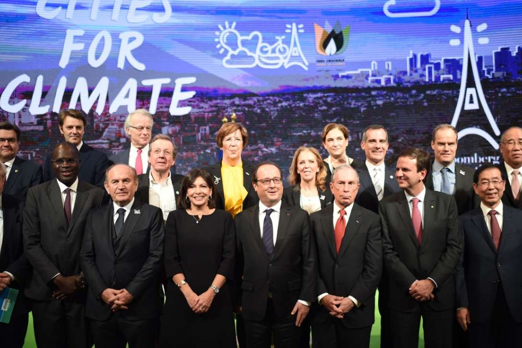 French President Francois Hollande (centre) poses with mayors from around the world, part of the Cities for Climate group, on December 4 at a Paris townhall during a summit on climate. Photo: AFP