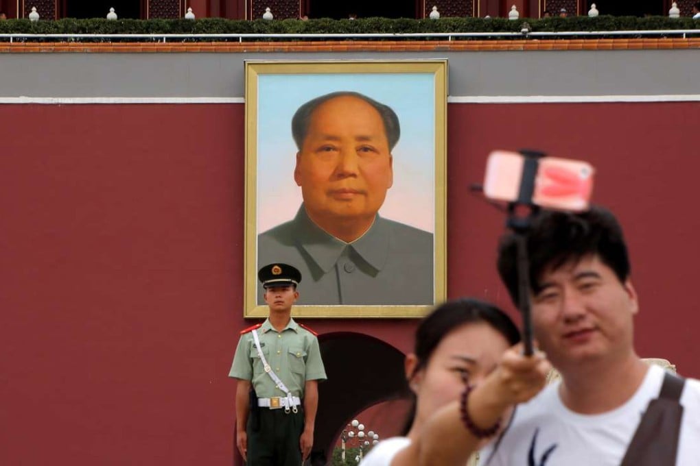 A couple take a selfie in front of a giant portrait of Mao at the Tiananmen gate in Beijing. Photo: Reuters
