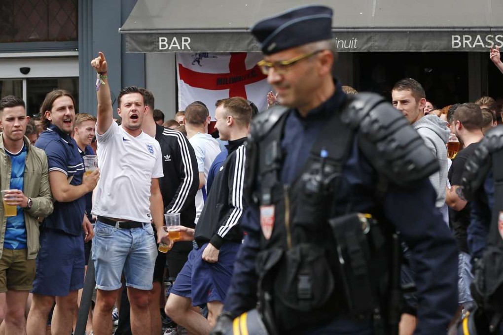 England supporters sing and gesture to French police in downtown Lille ahead of the Euro 2016 group B match against Wales in nearby Lens. Photo: AP