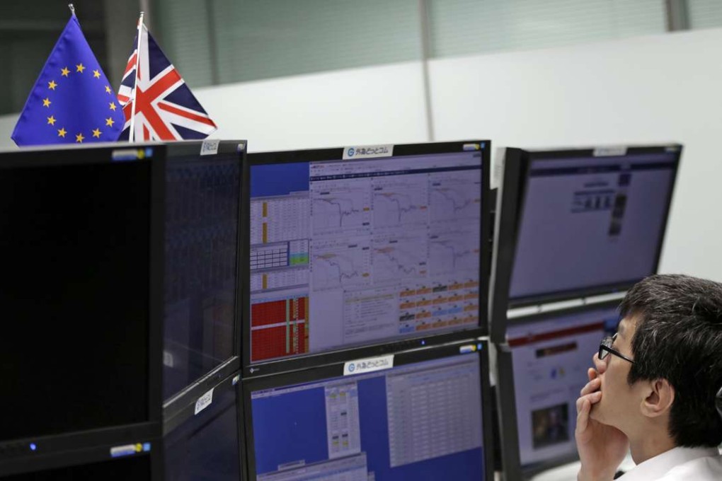 A money trader monitors computer screens at a securities firm in Tokyo on Friday, June 24. Photo: Eugene Hoshiko, AP