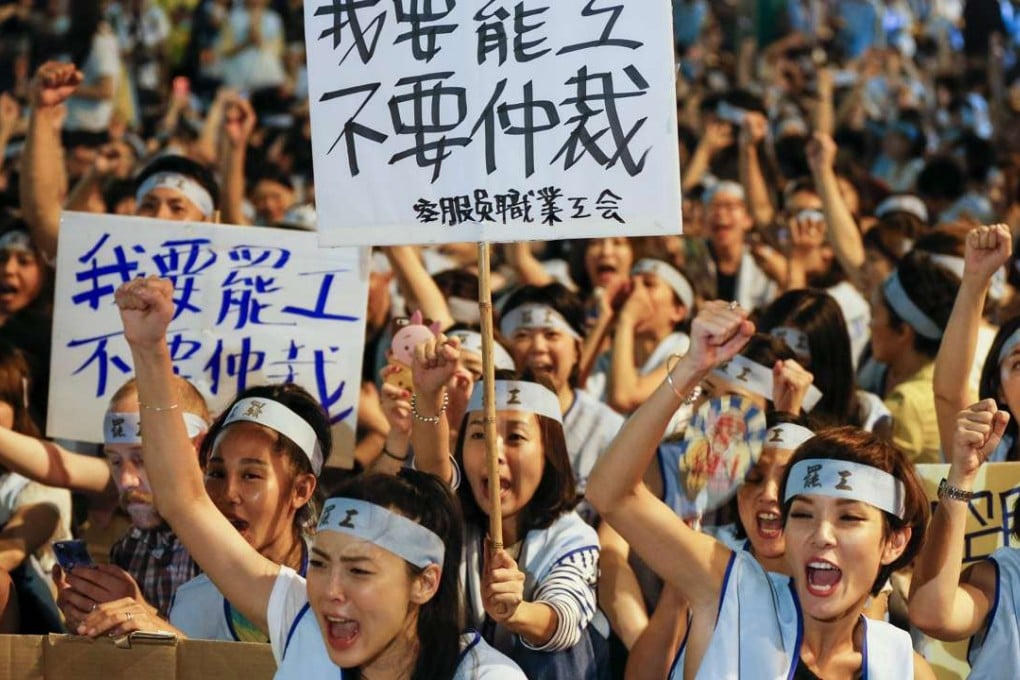 China Airlines flight attendants carry placards and shout slogans on Thursday during a protest outside the airline’s Taipei headquarters in Taipei, which led to a strike from midnight. Photo: EPA