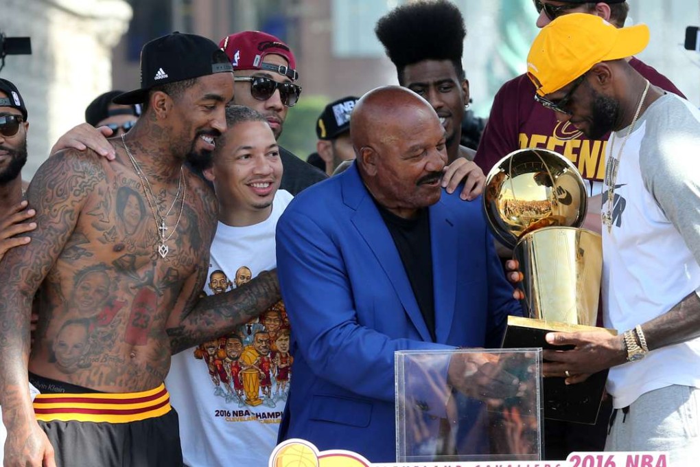 James Brown hands over the NBA championship trophy to LeBron James in Ohio. Photo: Reuters