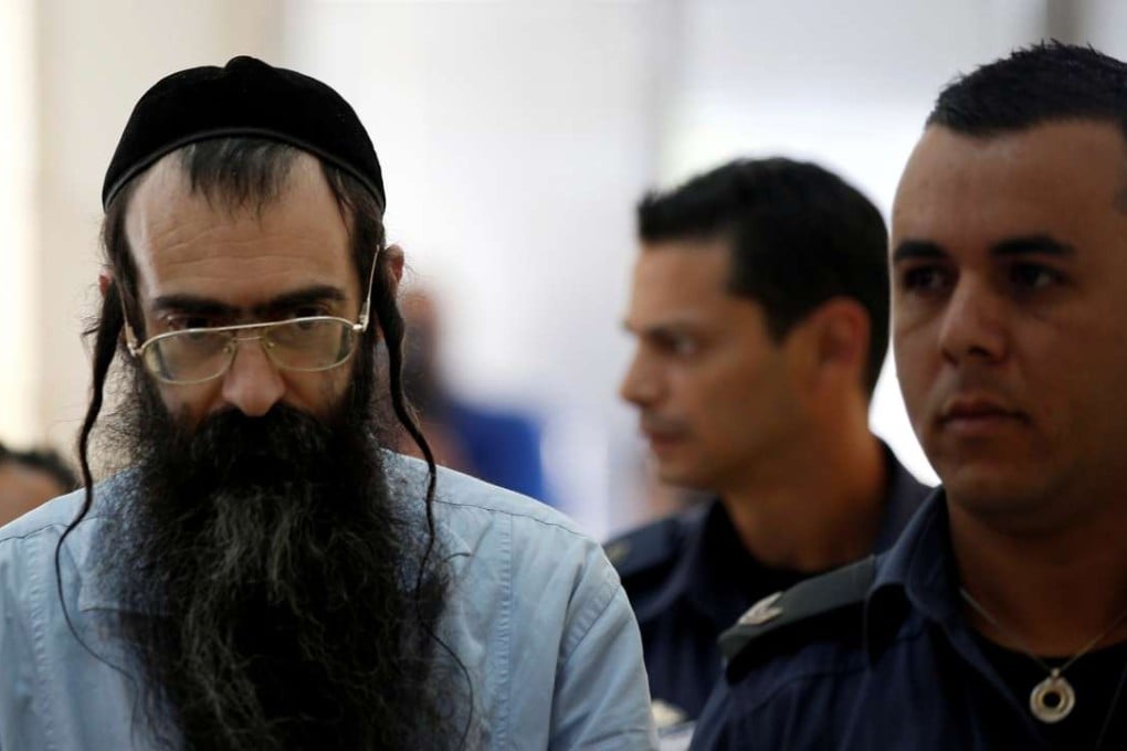 Yishai Schlissel (centre), convicted of killing a woman during the 2015 Jerusalem Gay Pride Parade, is escorted by security personnel before he is sentenced. Photo: Reuters