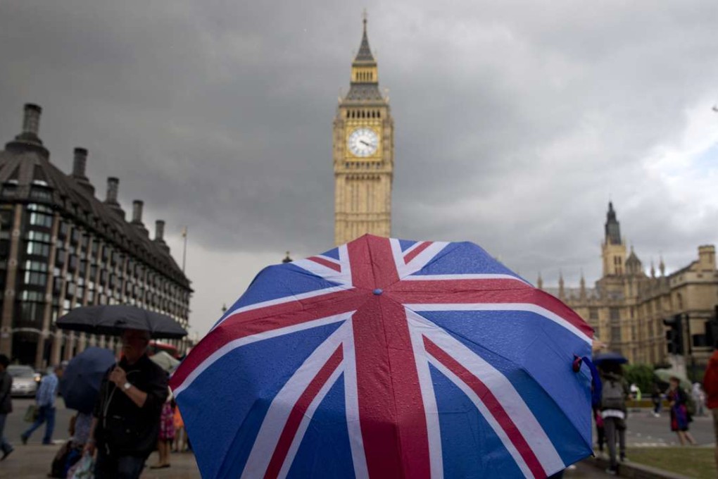 A pedestrian shelters from the rain beneath a Union flag themed umbrella as they walk near the Big Ben clock face and the Elizabeth Tower at the Houses of Parliament in central London on June 25, 2016. Photo: AFP