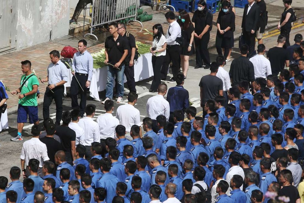 Family members and friends gather at the Ngau Tau Kok industrial building on Monday to pay their respects to the firefighters who died battling the blaze. Photo: Sam Tsang