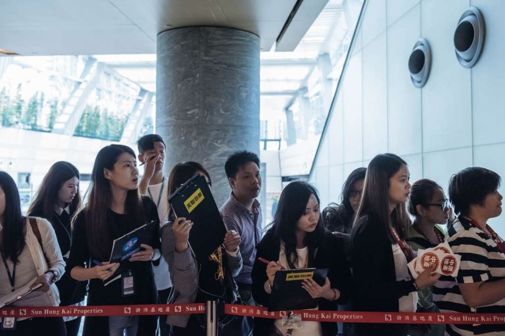 Real estate agents waiting last weekend for potential buyers outside the sales office of Park Yoho Venezia, a residential property developed by Sun Hung Kai Properties Ltd in Hong Kong. Anthony Kwan, Bloomberg