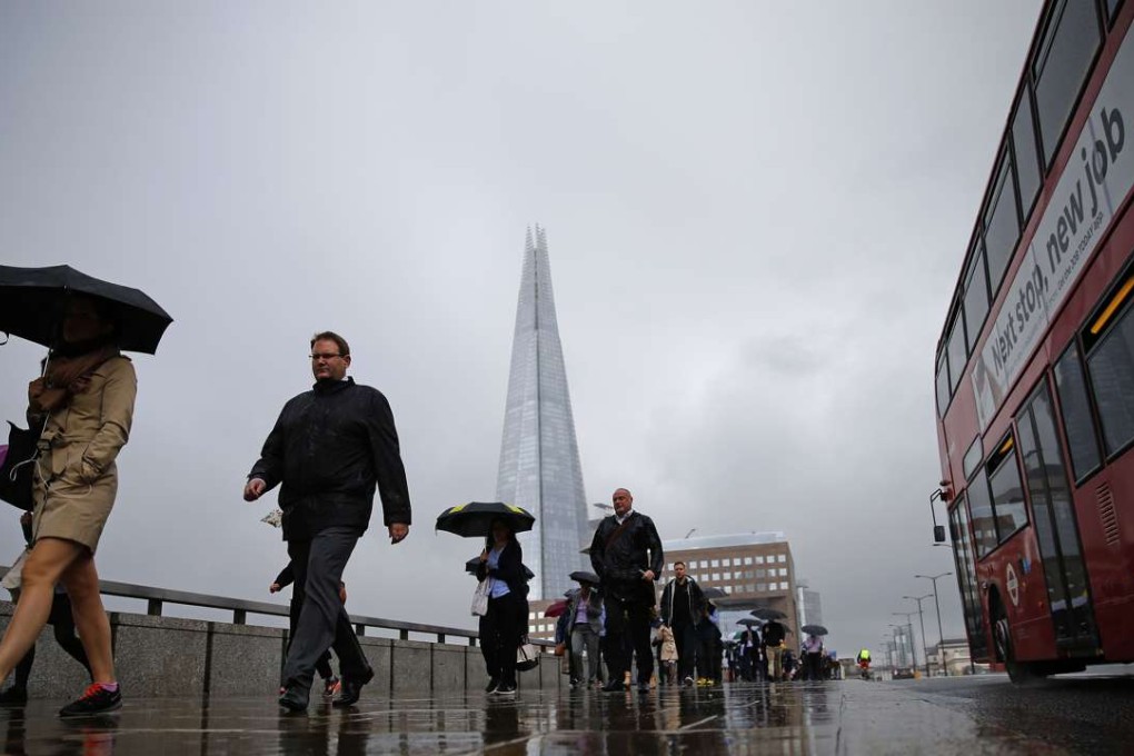 Commuters heading into the City of London walk in the rain across London Bridge, in front of the Shard skyscraper, in central London on June 27, 2016. Photo: AFP