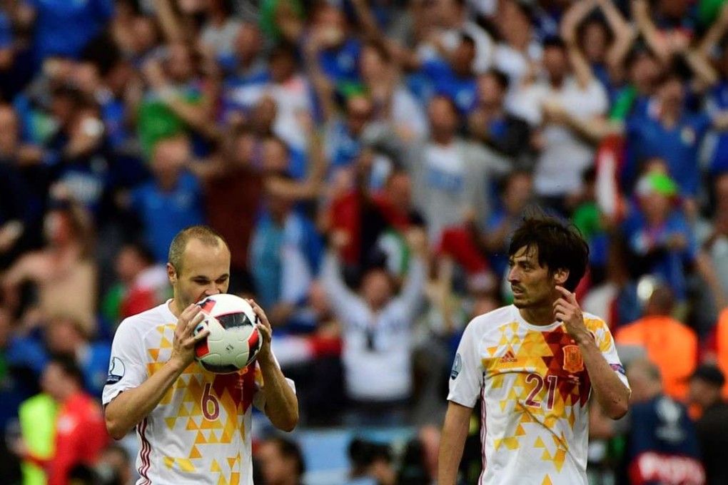 Spain's midfielder Andres Iniesta and David Silva react after the defeat AFP PHOTO / PIERRE-PHILIPPE MARCOU