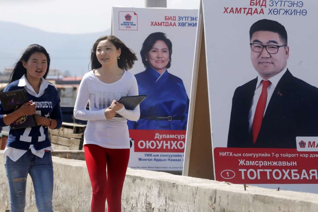 Women walk past posters of candidates from the Mongolian People's Party (MAH) on the outskirts of Ulan Bator. Photo: Reuters