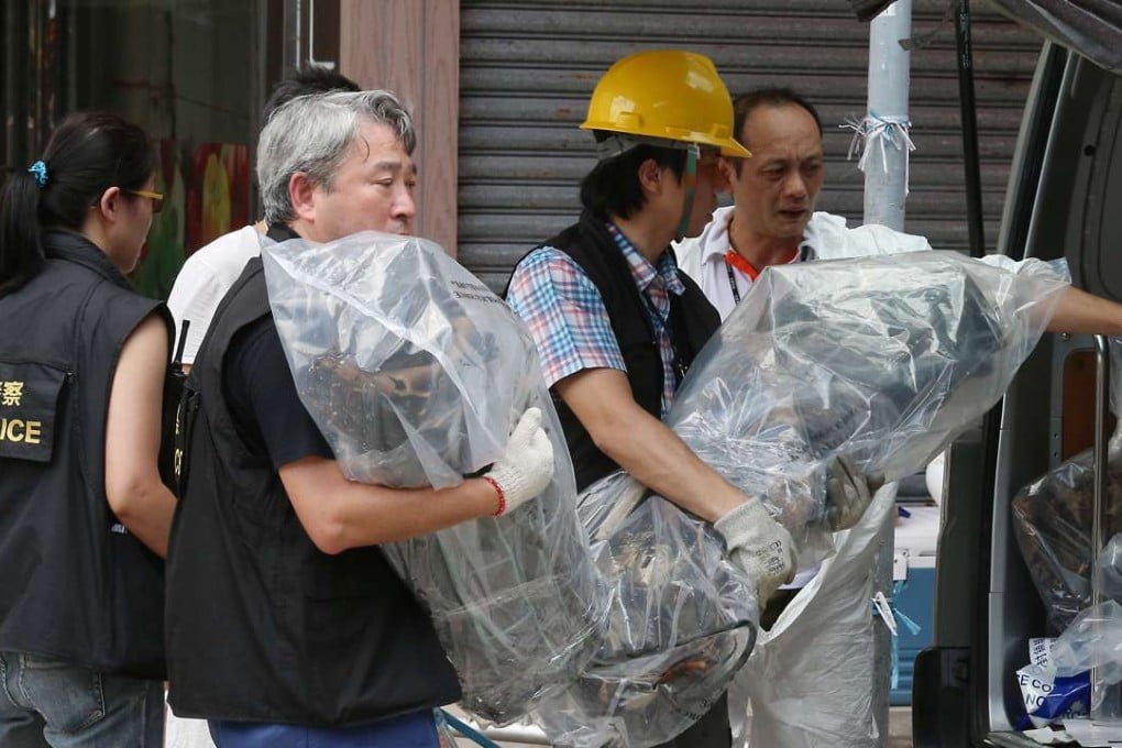 Police officers carrying items for their probe into the Ngau Tau Kok industrial building. Photo: K.Y. Cheng