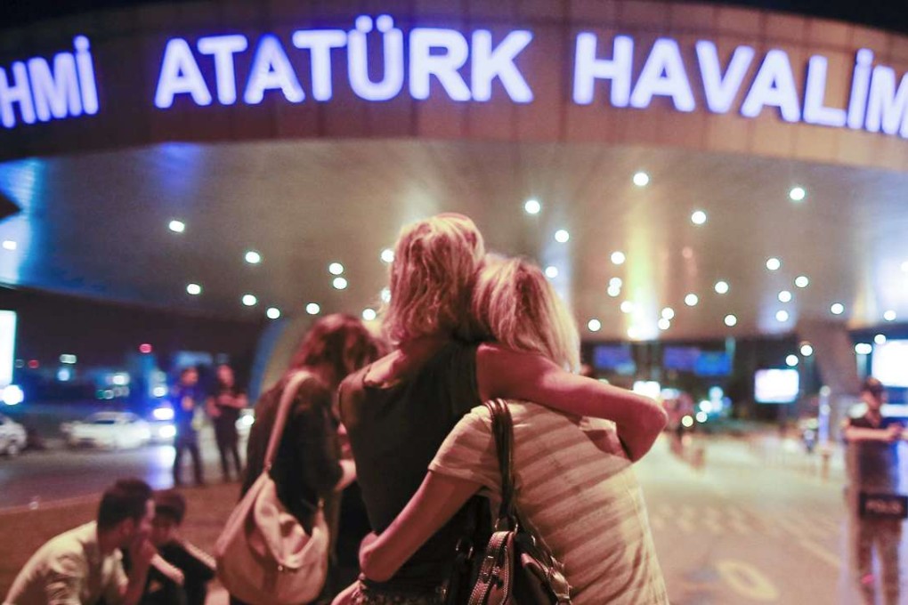 Passengers embrace each other at the entrance to Istanbul's Ataturk airport following their evacuation after a blast. Photo: AP