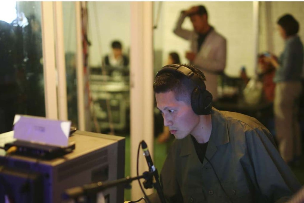 Hong Kong sound artist Samson Young performs his work “Nocturne” in Seoul, in which the recreated sounds of war are broadcast to the audience on hand-held radios. Photo: SCMP Pictures