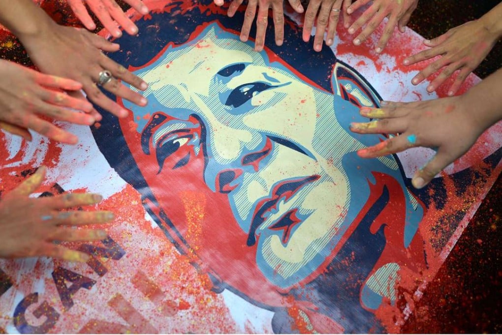 Activists with stained hands next to a portrait of Rodrigo Duterte, who was sworn as Philippine President on Thursday. Photo: Reuters